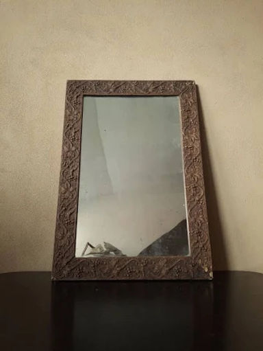 Mid-sized beautifully distressed and foxed antique carved wall mounted mirror frame with an antique silver mirror plate